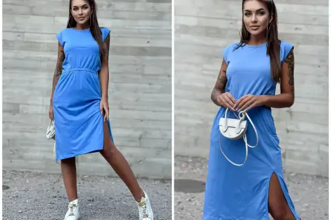 Modelka prezentuje błękitną sukienkę z rozcięciami. Idealne dodatki do błękitnej sukienki to biała torebka i sneakersy.