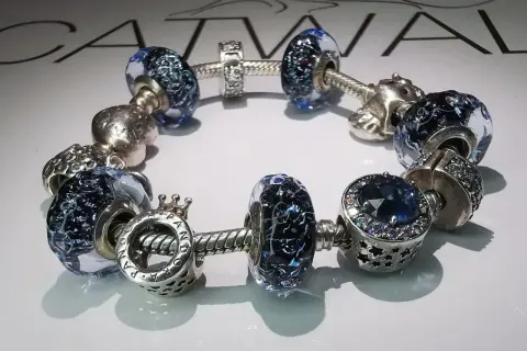 Bransoletka Pandora z niebieskimi szklanymi i srebrnymi charmsami. Idealna na pandora wymiana rozmiaru.