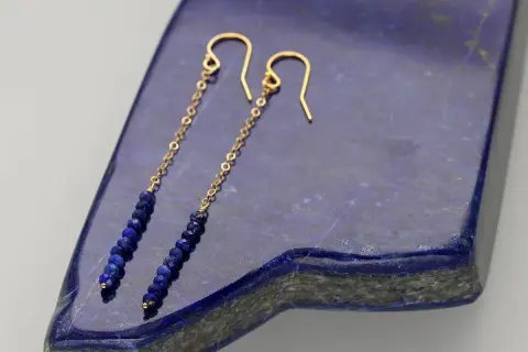 Eleganckie kolczyki z lapis lazuli na złotym łańcuszku, zakończone wygodnym zapięciem bigiel.