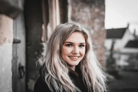 Uśmiechnięta blondynka z kolczykiem w wardze. Czy to jest ankier, co to?