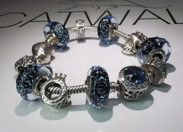 Bransoletka Pandora z niebieskimi szklanymi i srebrnymi charmsami. Idealna na pandora wymiana rozmiaru.